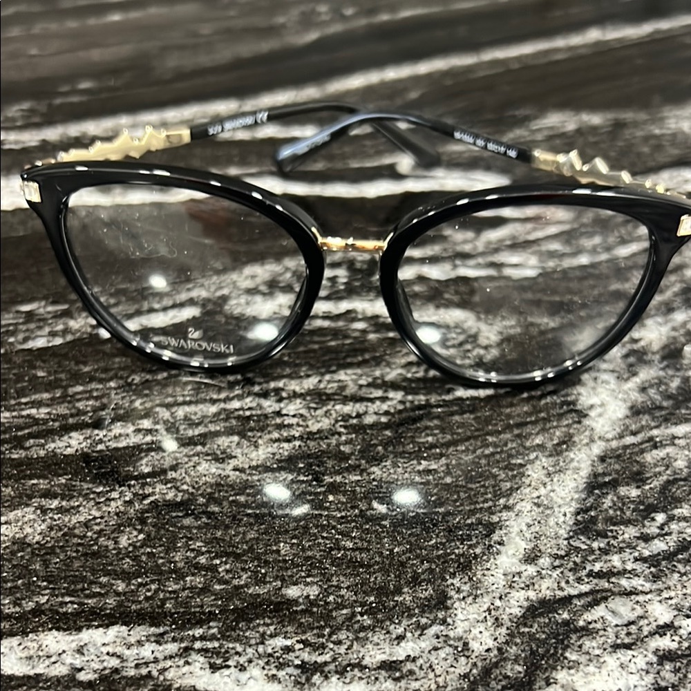 Swarovski Black and Gold Glasses with Cat-Eye Shape and Glossy Finish